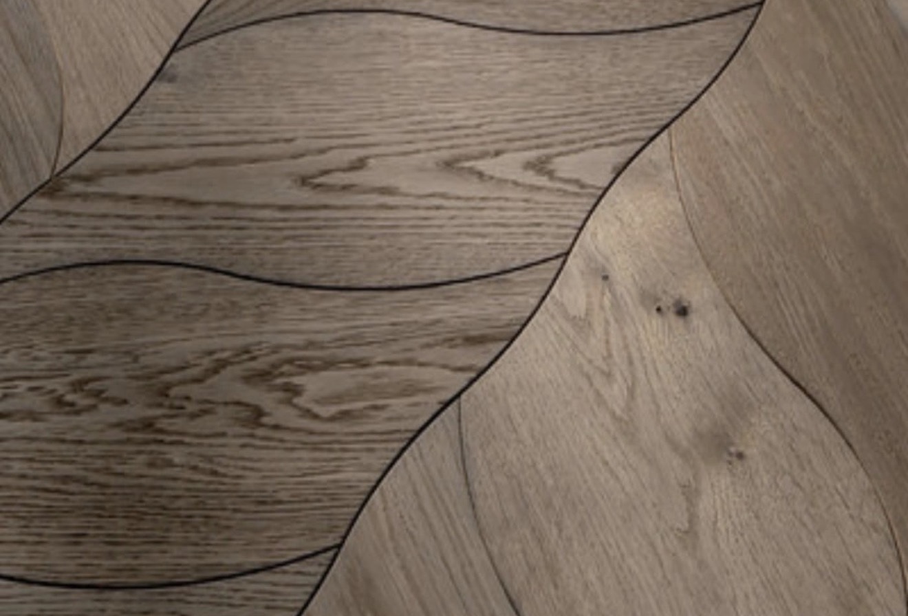 Close-up of wood flooring with curved leaf-shaped joints and natural grain